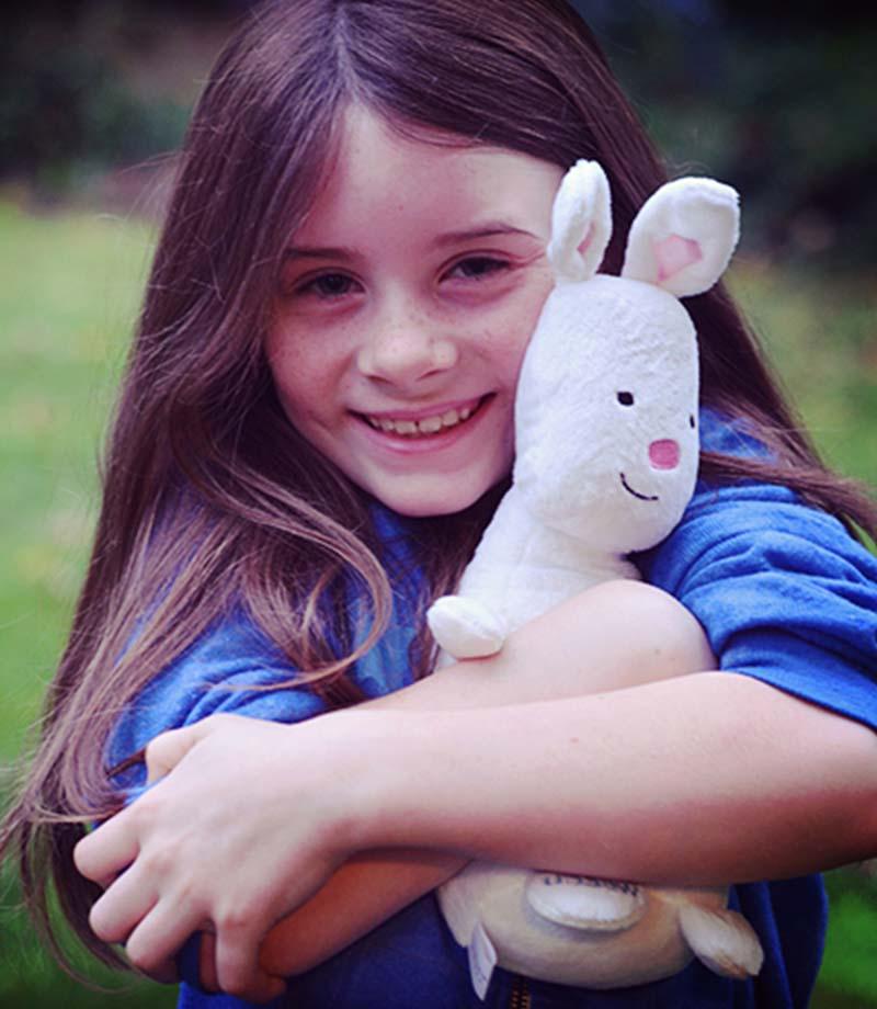 一个小女孩抱着WSECU的Munny Bunny毛绒玩具