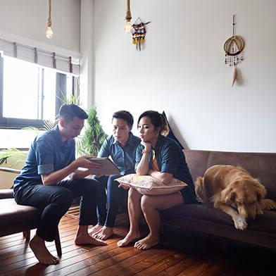 People chatting on couch with dog